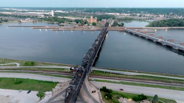 Downtown Davenport, Iowa railroad bridge over Mississippi River and train moving with drone video moving forward.