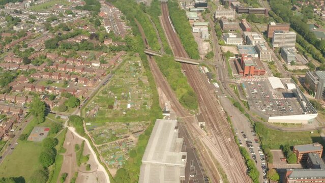 Aerial shot over Southwestern train arriving in the outskirts of Basingstoke town