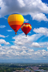 Hot air Balloon flying over the City, Landscape with hot air balloons flying over Chiang Mai City in a day of many clouds in the sky, Thailand, Asia