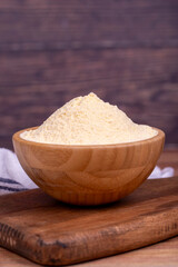 Corn flour on wood background. Cornmeal in wooden bowl. close up