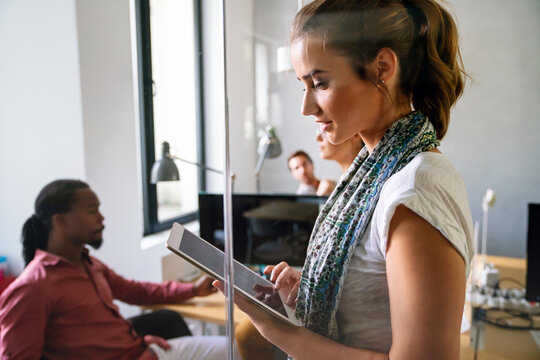 Portrait of happy young entrepreneur woman working with tablet in the office.