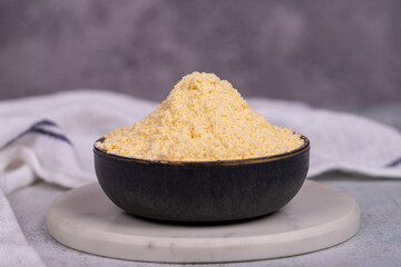 Corn flour on stone background. Cornmeal in bowl. close up