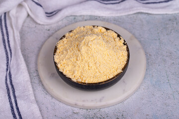 Corn flour on stone background. Cornmeal in bowl. close up