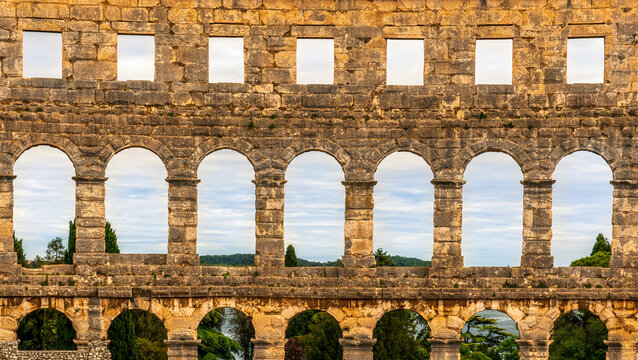 ancient wall with arches and windows of historical building, ancient architecture outdoor , roman arena in Pula