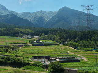 青空の下に広がる山間部の棚田
