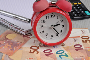 Concept du temps c'est de l'argent avec des billets de banque en euros et un réveil