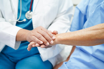 Doctor holding hands Asian elderly woman patient, help and care in hospital.