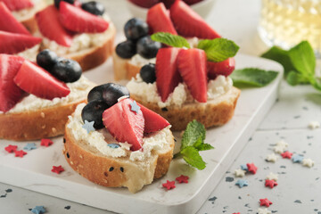 American flag sandwich with strawberries, blueberries, whipped sweet cream, soft cheese on toast bread. 4th of July American Independence Day food. Independence or Patriotic Day breakfast idea Mock up