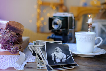 old family photos in vintage interior, stack nostalgic sentimental pictures, vintage photographs 50s, 40s, retro accordion camera on wooden table, concept genealogy, memory ancestors, family tree