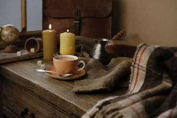 cup with drink coffee on old vintage wooden table, metal coffee maker, candles burn, caffeine...
