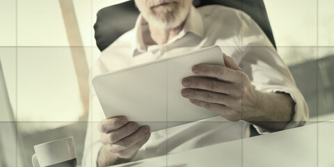 Senior businessman using a digital tablet, hard light, geometric pattern