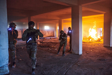  A group of professional soldiers bravely executes a dangerous rescue mission, surrounded by fire in a perilous building.