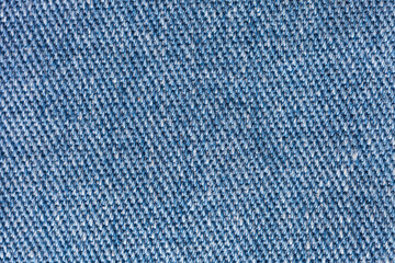 Close-up of blue denim. Gray and blue textile background of intertwined natural cotton threads....