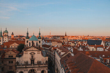 Fototapeta na wymiar Old Town of Prague under the warm rays of the setting sun illuminating the rooftops of historic buildings in the capital of the Czech Republic. The centre of Prague
