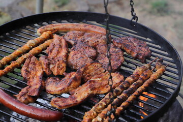 various meat and sausages on the charcoal grill