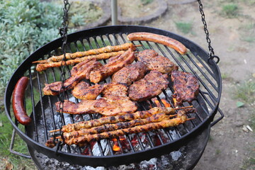 various meat and sausages on the charcoal grill