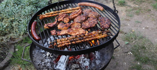 various meat and sausages on the charcoal grill