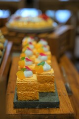 Orange mini cakes on display. Garnish on top. Cake potong