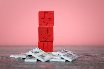 Red downward arrows on top of money. Bankruptcy, business loss, underpaid concept