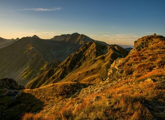 Sunrise from the ridge of the Western Tatras, Rohace with a view of the Salatin mountain with grass illuminated by the rising sun, camping and bivouac in nature. Tatras, tourist theme, tourist trail.