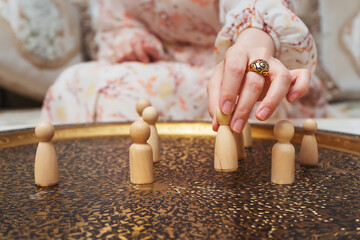 girl with wooden figurines of people on the table. subject photo session of humanoid toys in the...