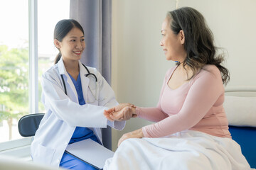 Obraz premium Young Asian nurse caregiver with 60 year old Asian woman giving advice and encouragement Take a history and recommend appropriate treatment to live happily in retirement in the clinic.