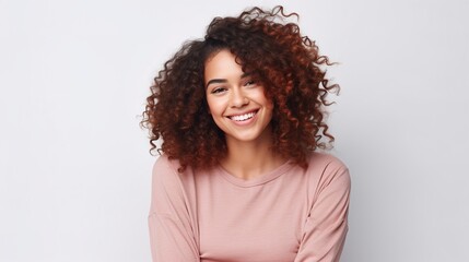 Radiant Smile: A young woman with beautiful, voluminous curly hair beams a genuine, joyful smile. Her warm gaze and radiant expression exude confidence and happiness. 