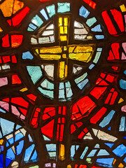 Window in the church, stained glass, colored mosaic in the form of a cross.