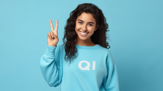 Young happy latin woman student showing ok hand okay sign winking isolated on blue background. Smiling female model advertising sale offer presenting promotion recommending discounts, generative ai