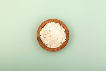 Guar gum powder or guaran in wooden plate, top view. Food additive E412. Guar Gum used in cosmetics and food industry