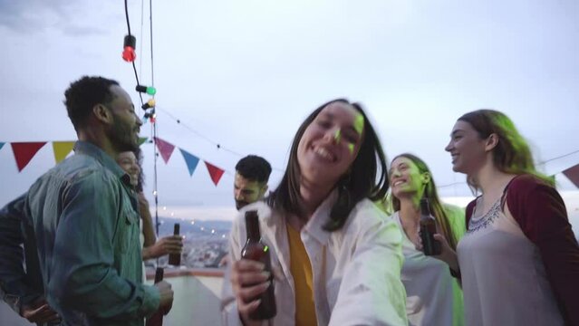 Point of view of a happy caucasian woman bringing her boyfriend towards a rooftop party. Unrecognizable man following a pretty lady towards the dance floor.
