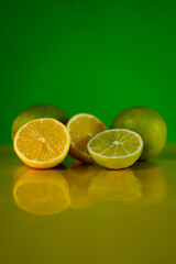 fresh limes and lemons with a green background 
