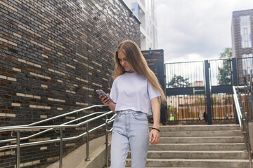 young woman with a phone on the background of city buildings