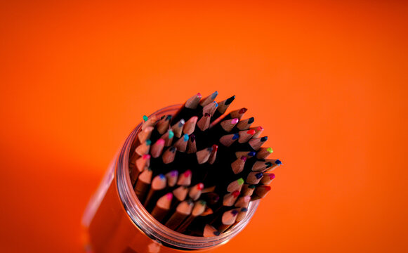 boc of coloured pencils with an orange background