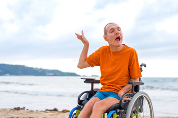 A disabled person in a wheelchair on the beach in summer
