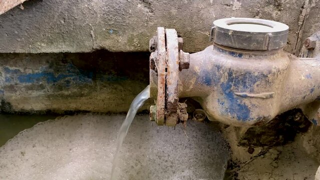 Liquid waste mixed with chemicals coming out from the water meter pipe. Pouring water produce foam. Chemical waste water from industrial process. Wastewater Treatment Procedure (WWTP)