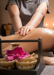 Body massage treatment. Woman having massage in the spa salon. Masseur working on his back.with useful herbs.