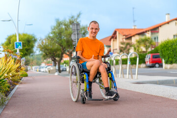 Portrait of a very cheerful disabled person in a wheelchair on vacation in the city