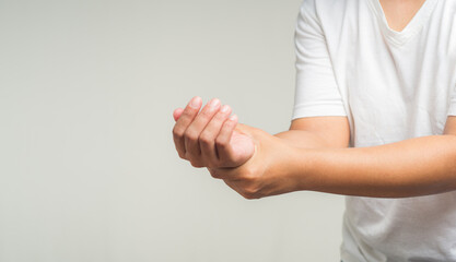 Close-up of hands suffering from wrist pain. Causes of hand shaking include Parkinson's disease,...