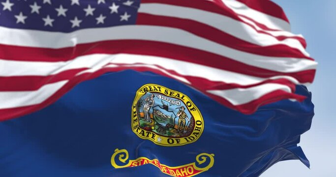 Idaho state flag waving with the national flag of the US blurred in the foreground