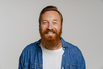 Mid bearded man in denim shirt smiling at camera standing isolated