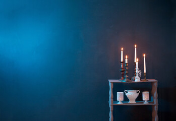 candlesticks with burning candles on  dark blue background