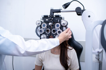 Woman optical shop customer doing eyesight measurement with optical phoropter check eye distance for eyeglasses is optical  eye shop service