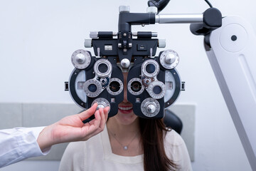 Woman optical shop customer doing eyesight measurement with optical phoropter check eye distance for eyeglasses is optical  eye shop service