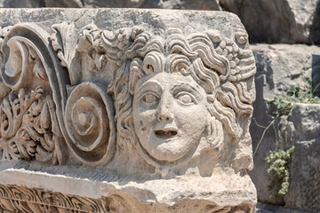 Marble decoration with tragedy mask relief. Close up fragment. Ruined ancient theater in Myra, old antique city (Demre, Turkey). History, art or theater concept