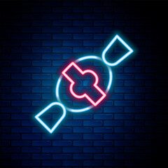 Glowing neon line Candy icon isolated on brick wall background. Happy Halloween party. Colorful outline concept. Vector