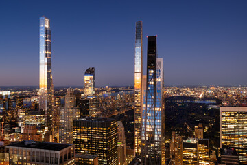 Aerial view of Billionaires' Row skyscrapers in Midtown Manhattan at dusk with view of Central Park. Last rays of sun reflect on the supertall buildings. New York City
