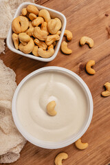 Fototapeta na wymiar Cream cheese made of cashew on wooden table, healthy vegan alternative