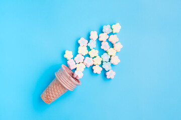 Multicolored Marshmallows out of ice cream cone on blue background, Flower Shaped Marshmallows