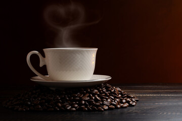 Black coffee or hot tea in a cappuccino espresso cup, breakfast food with coffee beans on a wooden table Isolated on a dark background, top view